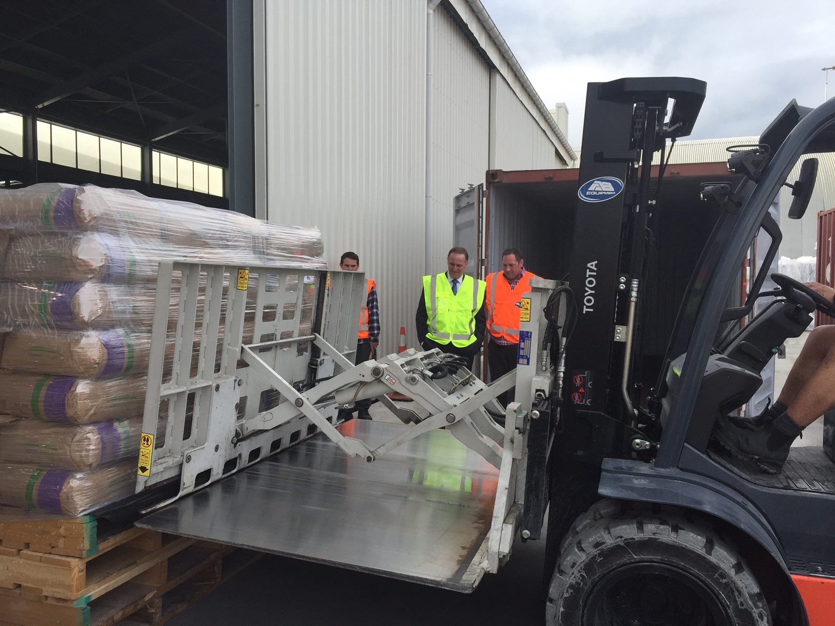 Toyota forklift loading shrink-wrapped pallets into a shipping container at the Ali Arc Logistics warehouse